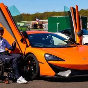 Adult in Wheelchair Next To Supercar