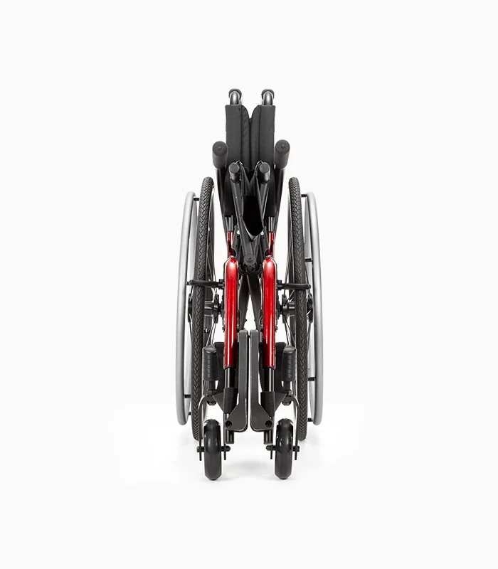 Ki Mobility Catalyst wheelchair with red frame, folded, front view.