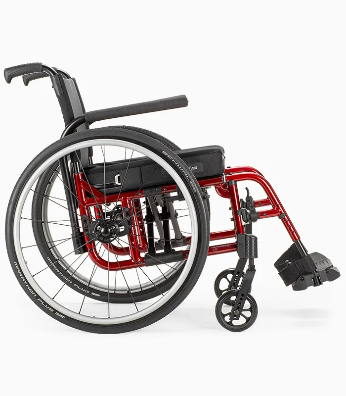 Ki Mobility Catalyst wheelchair with red frame, side view.