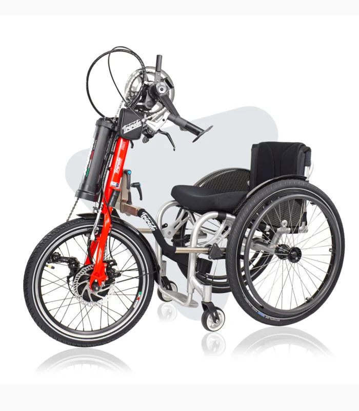 TriBike handcycle attachment with red fork and hand-crank pedals, connected to a manual wheelchair.