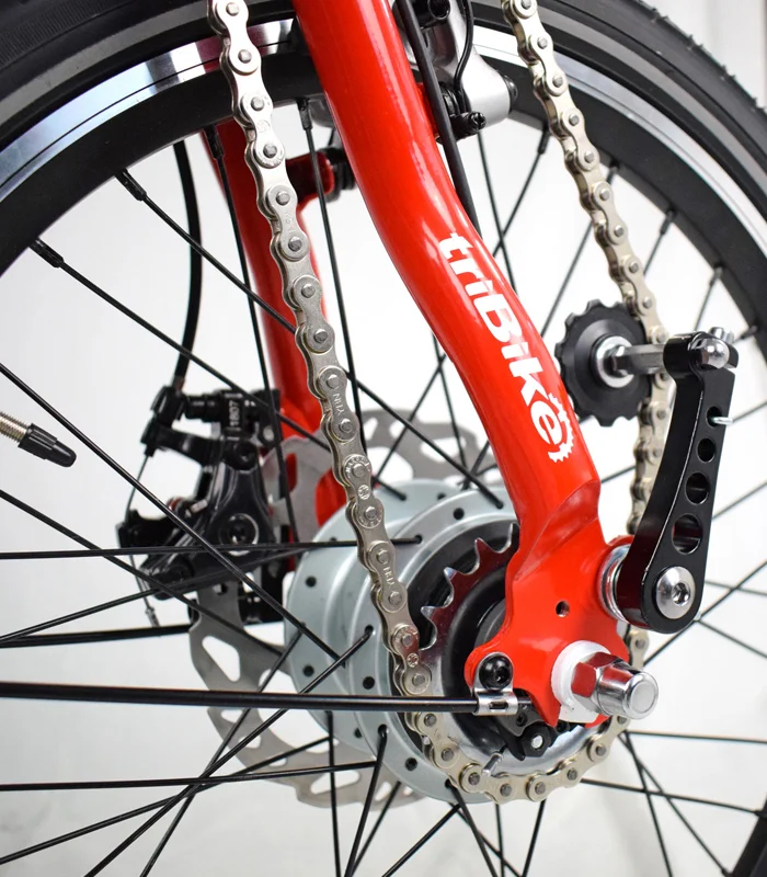 Close-up of the TriBike's chain and hub with red frame branding.
