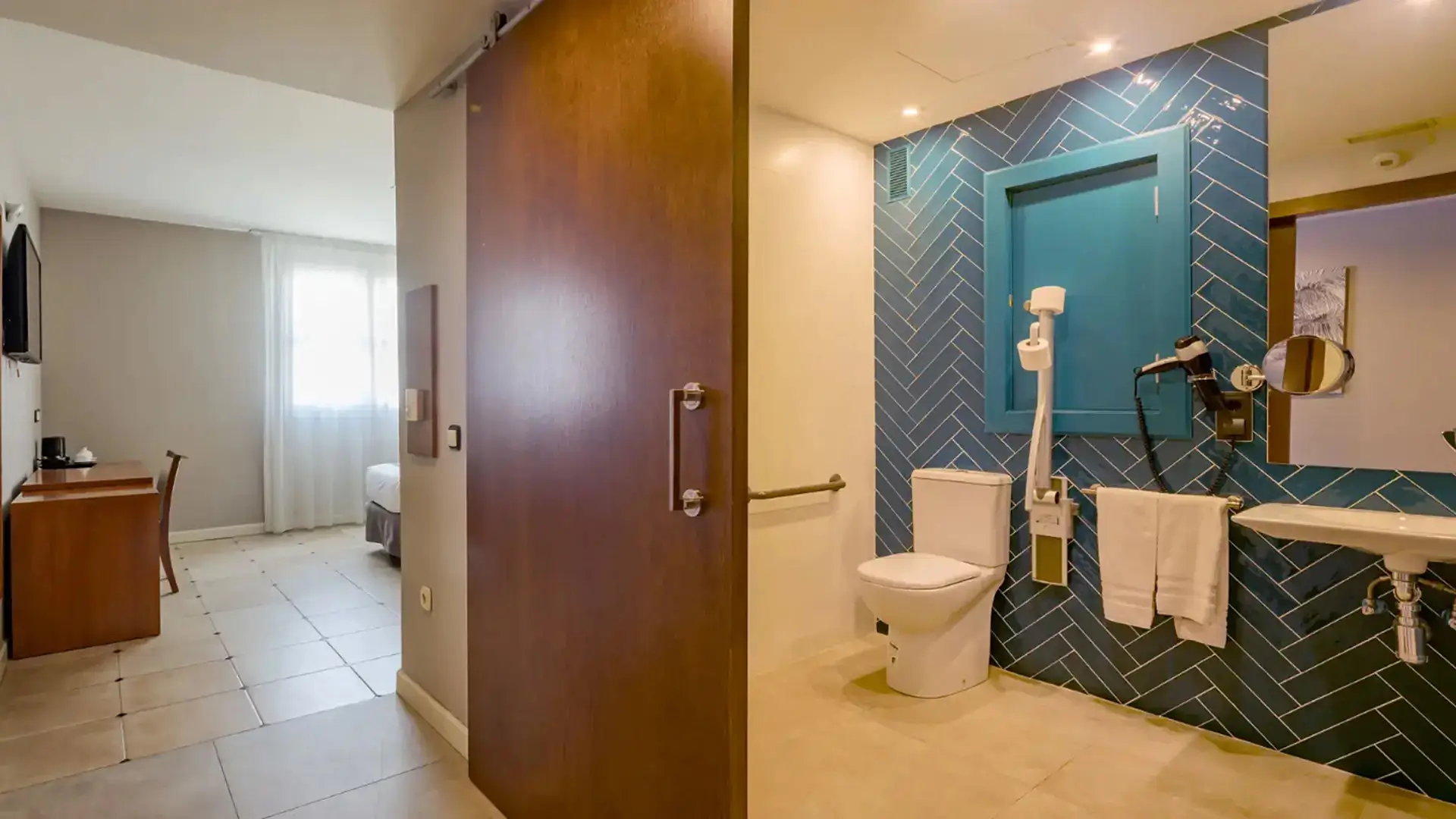 Hotel room split view showing bedroom and accessible bathroom.