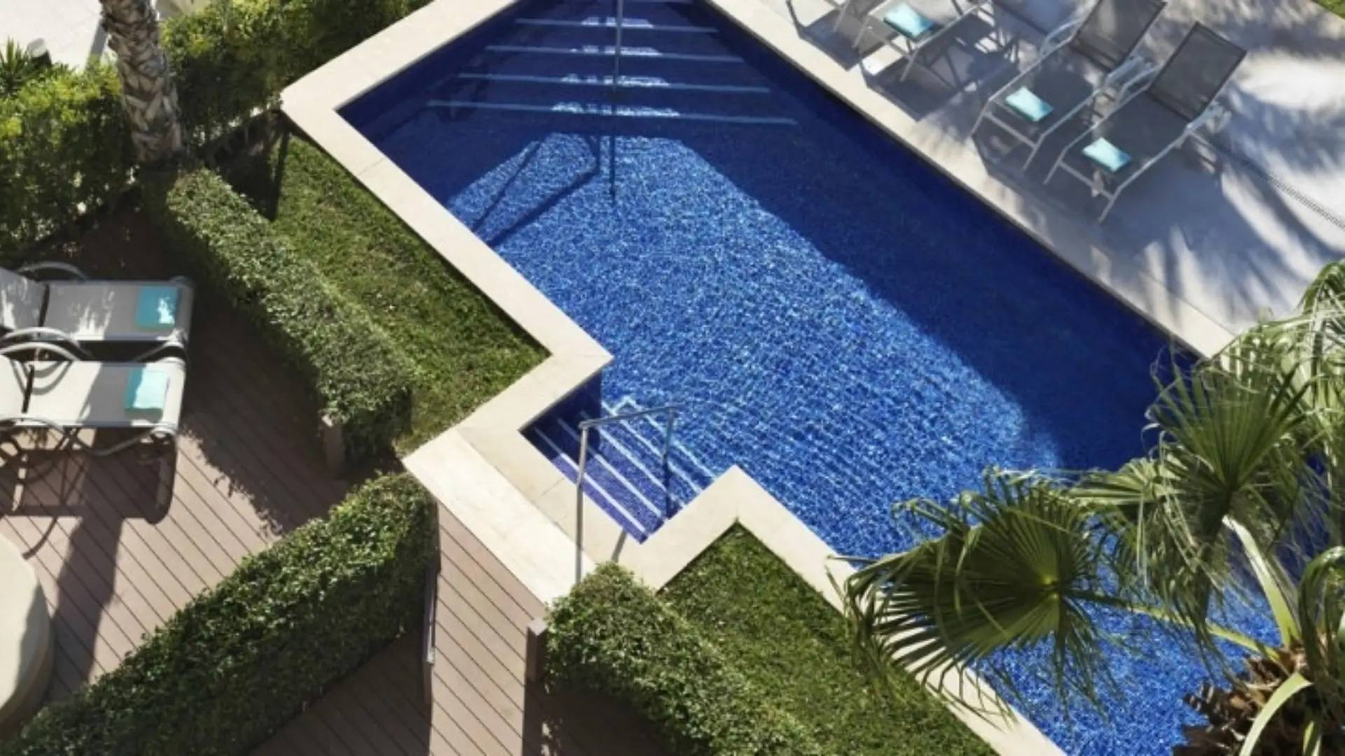 Aerial view of angular pool with loungers.