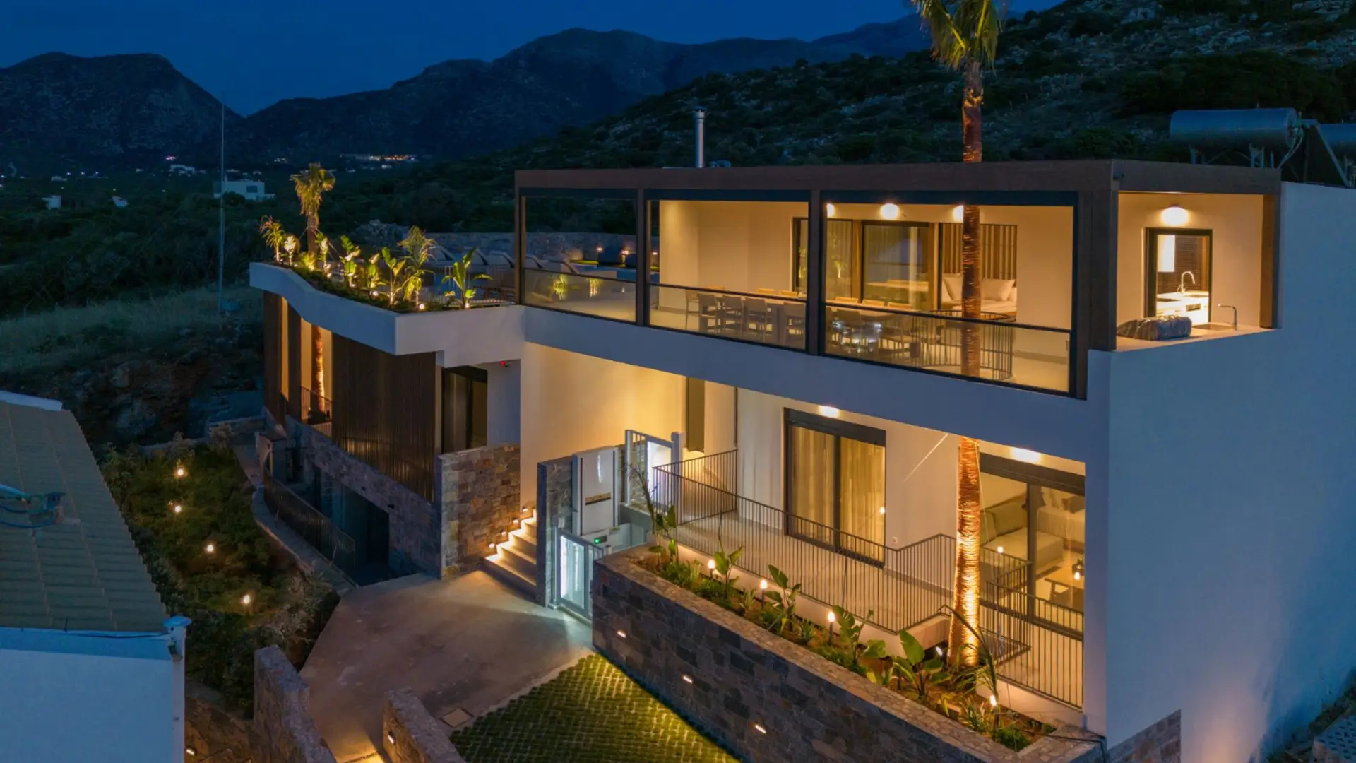 Modern villa exterior lit up at night.