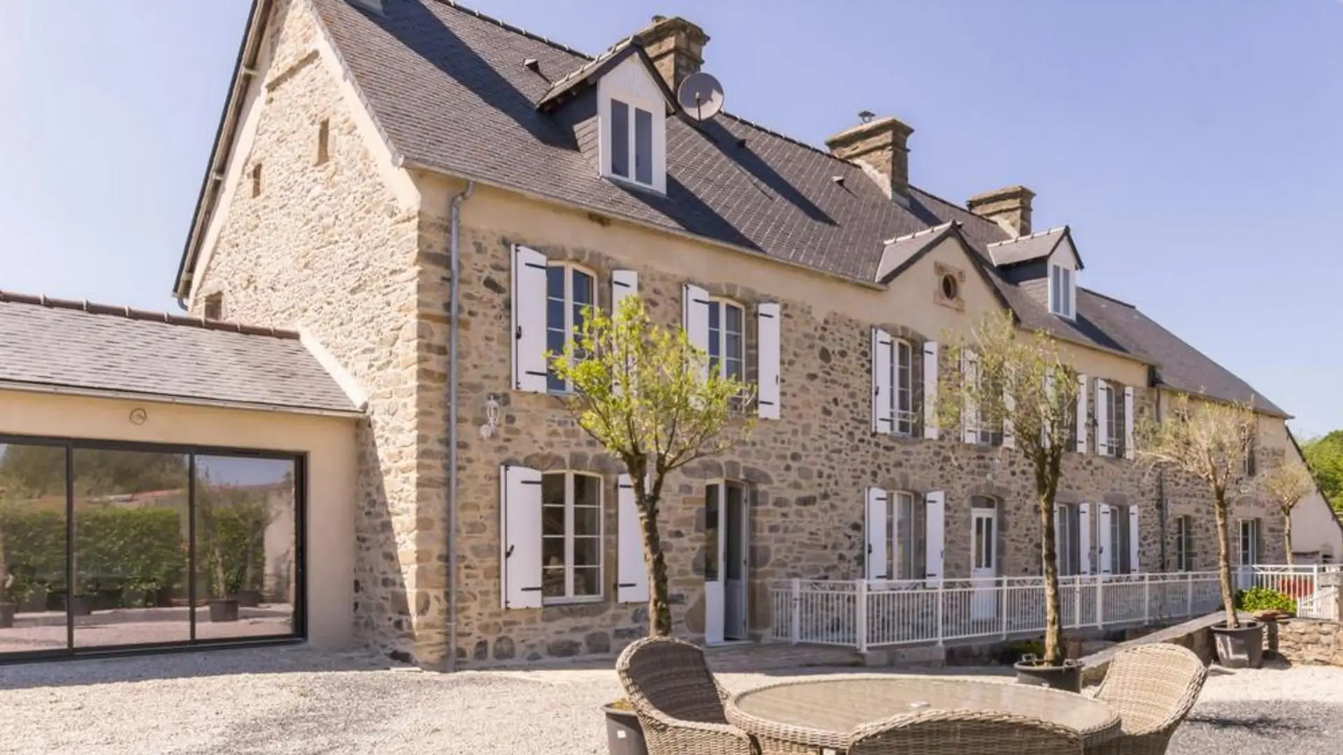 Stone farmhouse exterior with terrace seating.