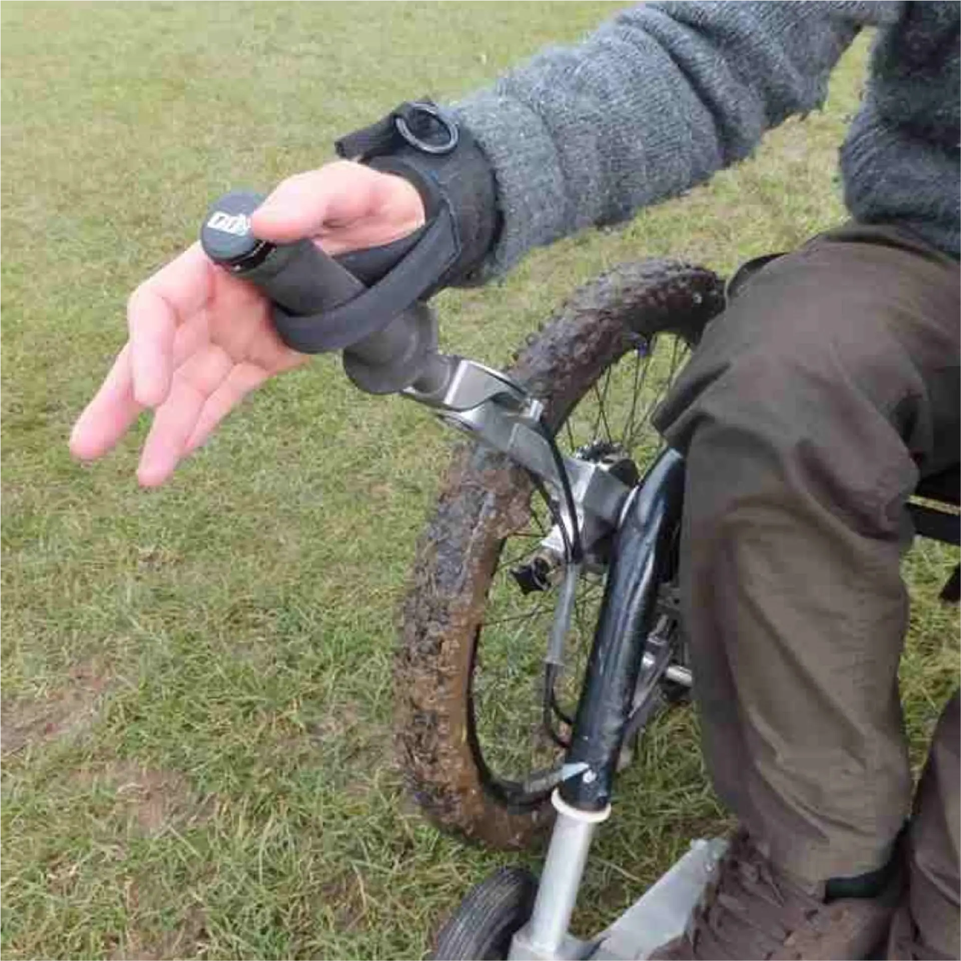 Wrist strap looping around a mountain bike brake lever, with the wearer's hand relaxed and open.