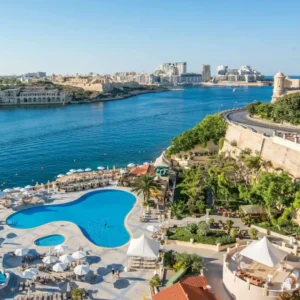 Hotel pool overlooking harbor and fortress walls.