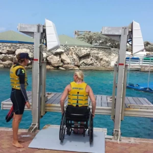 Wheelchair user on accessible dock lift by water.