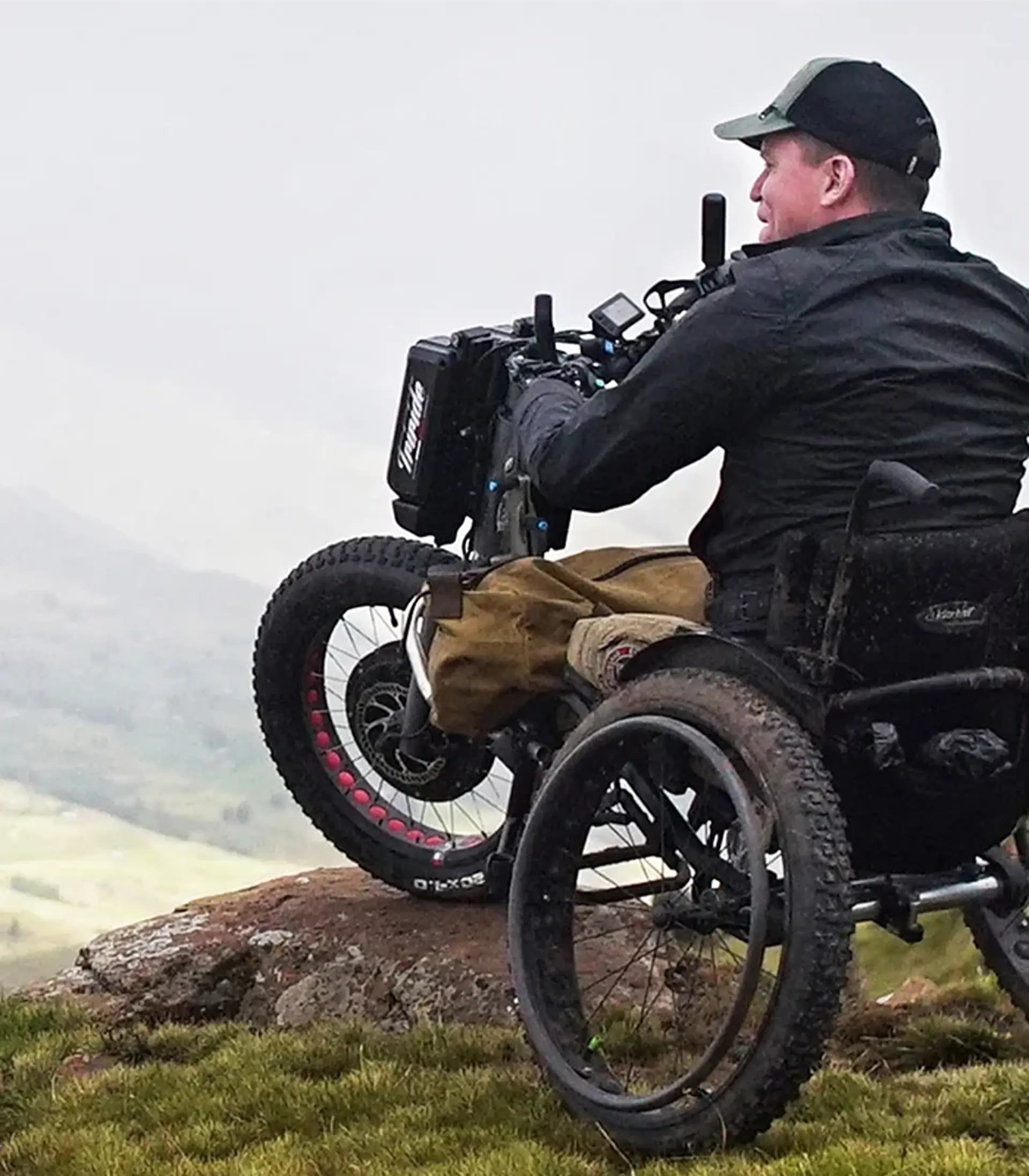 Man using the Triride MTW attachment to ride over rocky terrain on a hillside.
