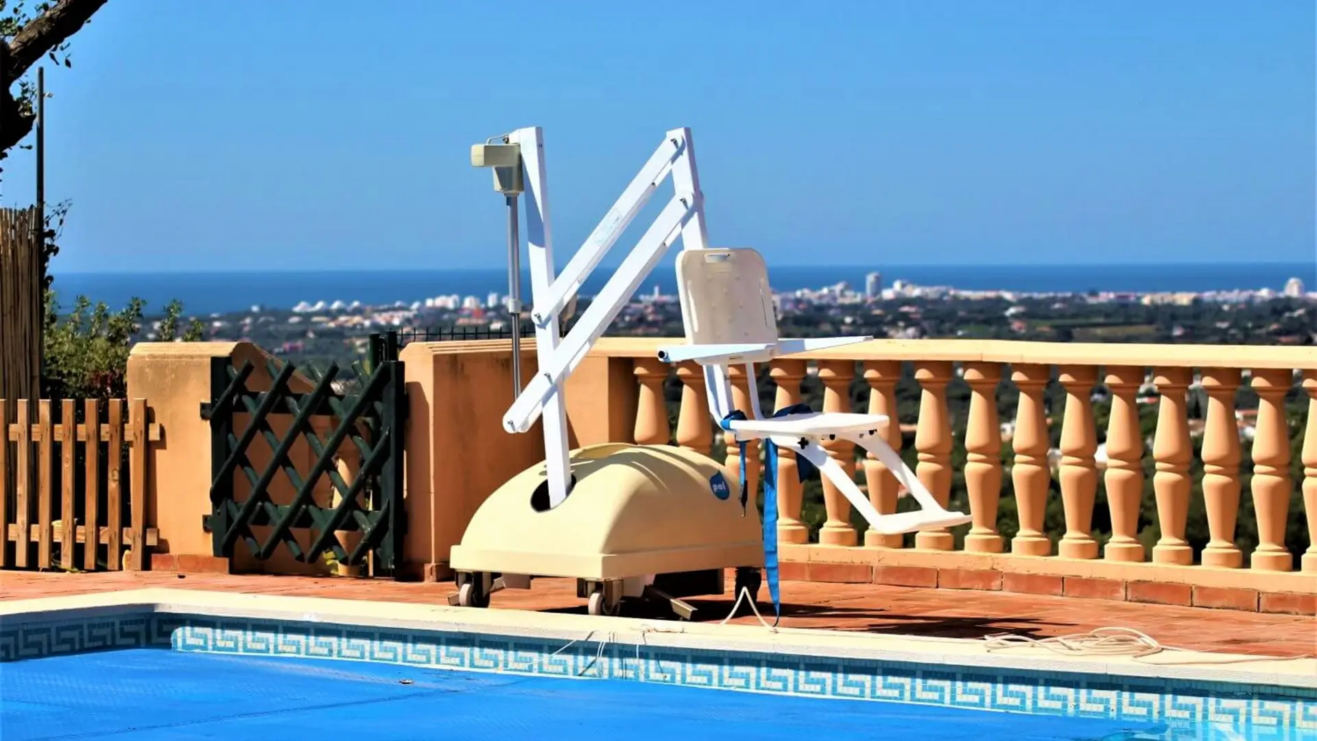 Portable pool hoist on terrace overlooking coastline.