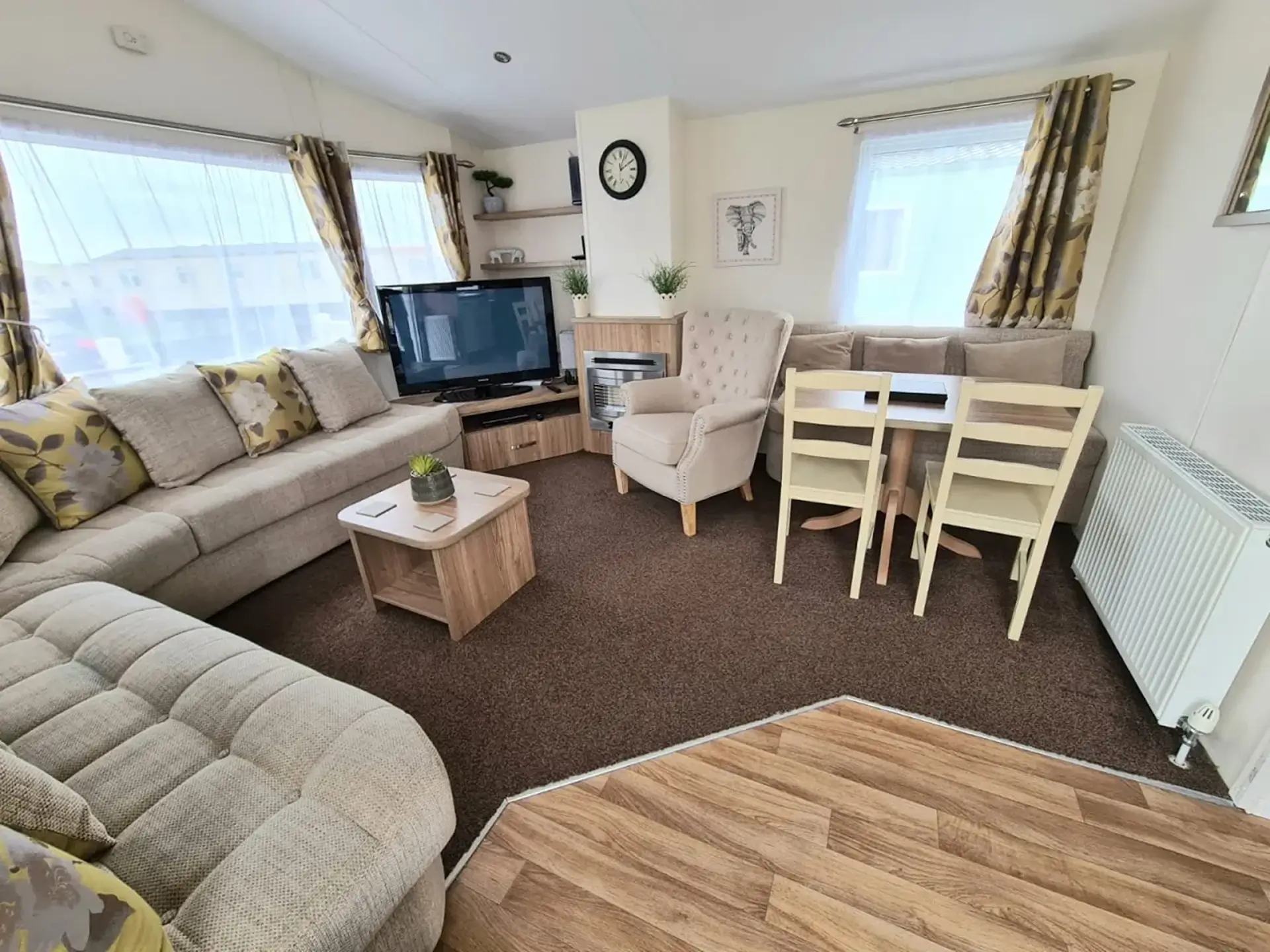 Lounge with corner sofa, TV, fireplace and dining table.