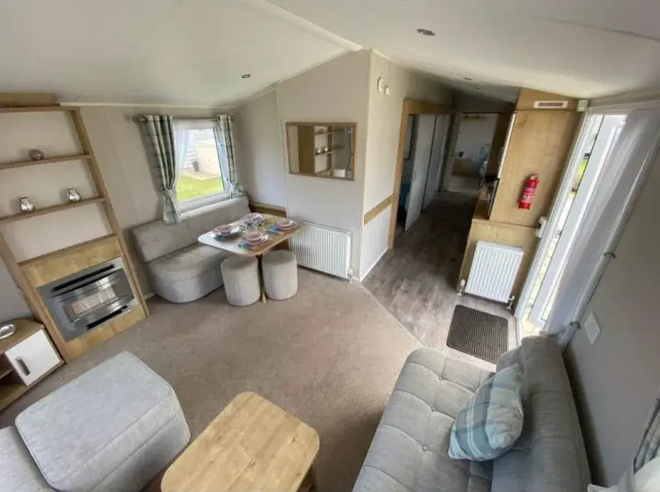 Lounge with grey sofas, dining nook, and hallway view.