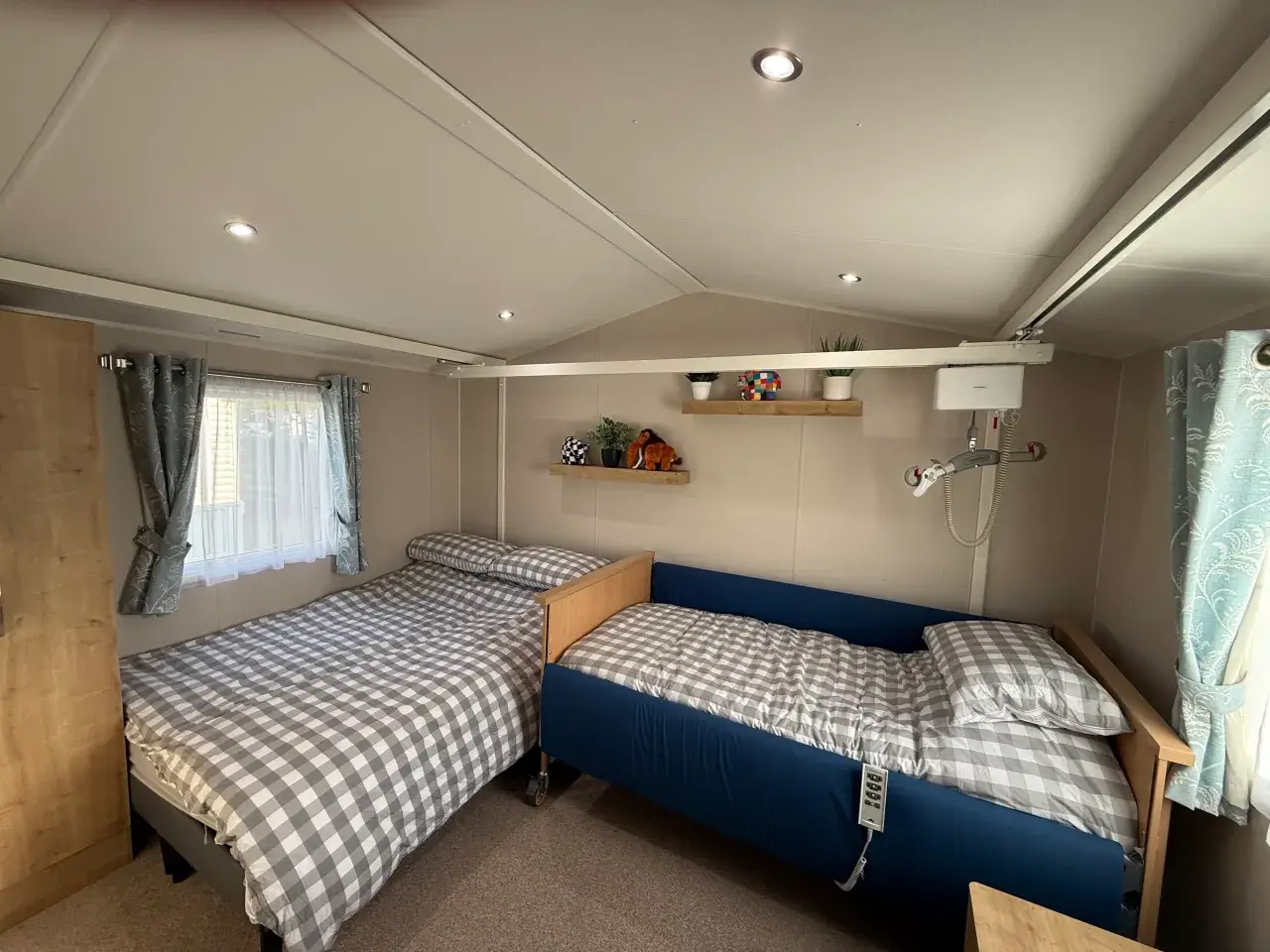 Twin room with adjustable bed, ceiling hoist, and standard bed.