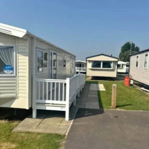 Row of beige static caravans with accessible ramp and pathway.