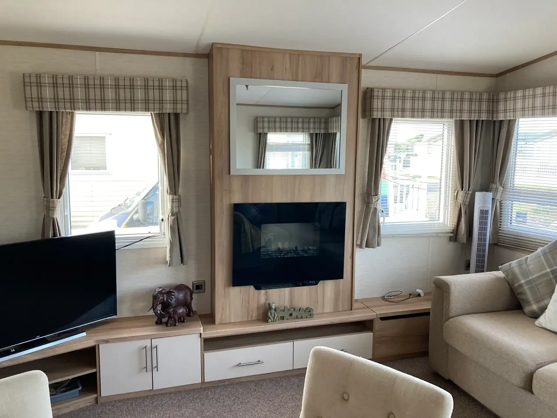 Lounge with TV, wall-mounted mirror, and electric fireplace unit.