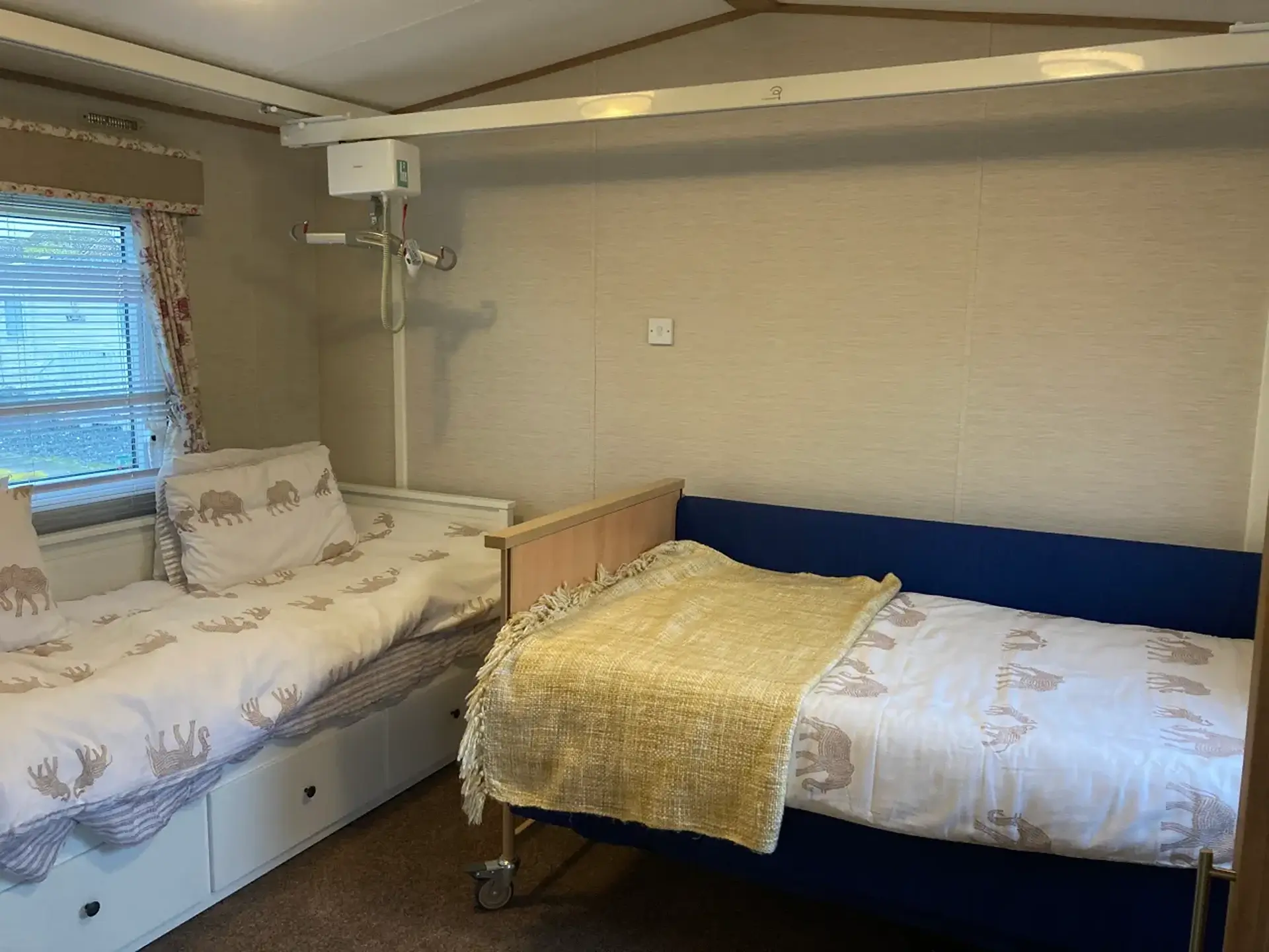 Close-up of two beds with a ceiling hoist track above.
