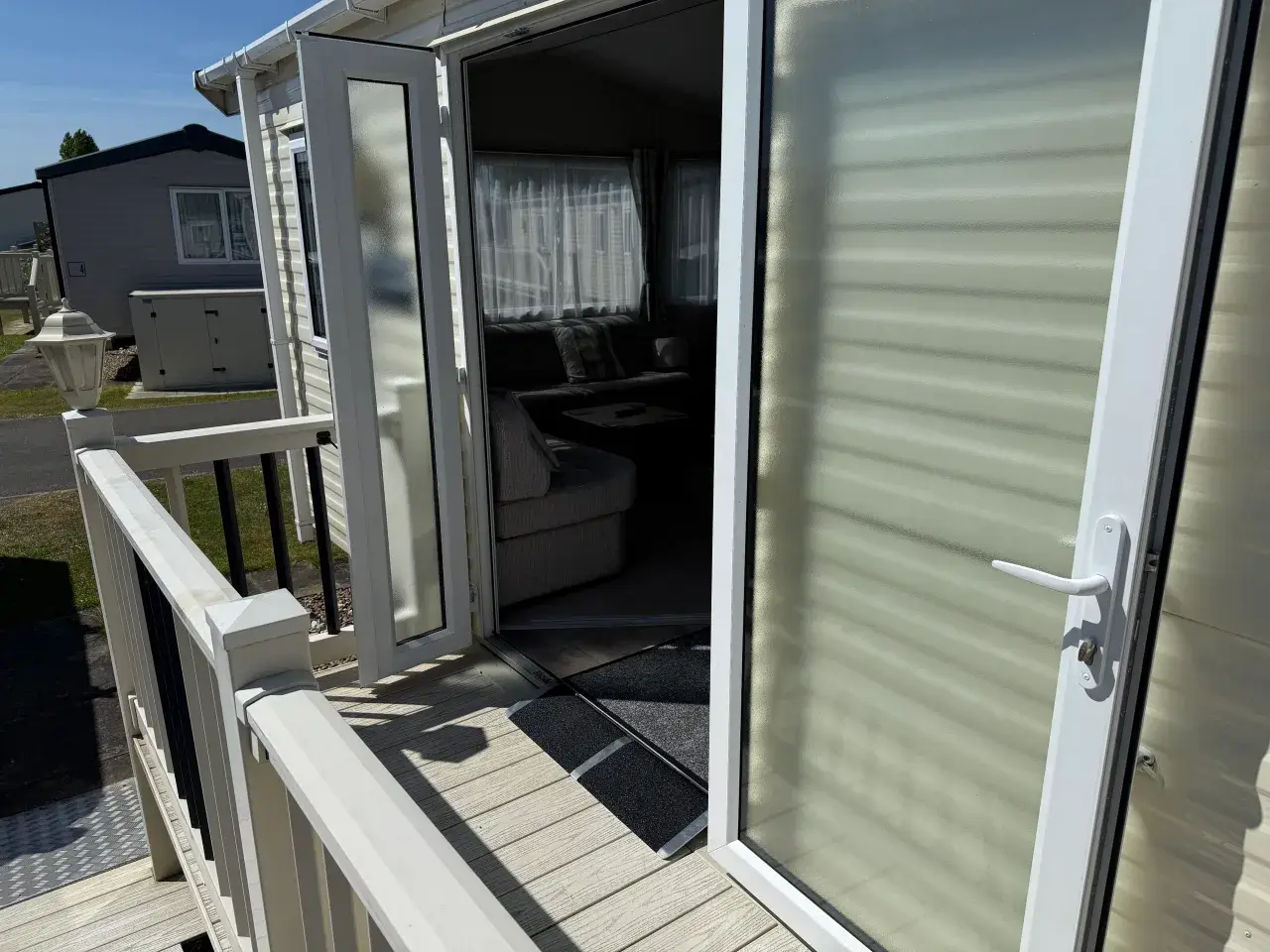 Caravan entrance with double doors, ramp mat, and decking.
