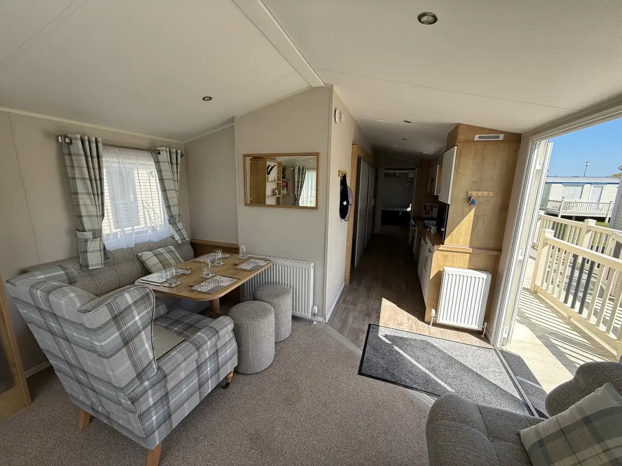 Lounge and hallway view with dining table and open patio doors.