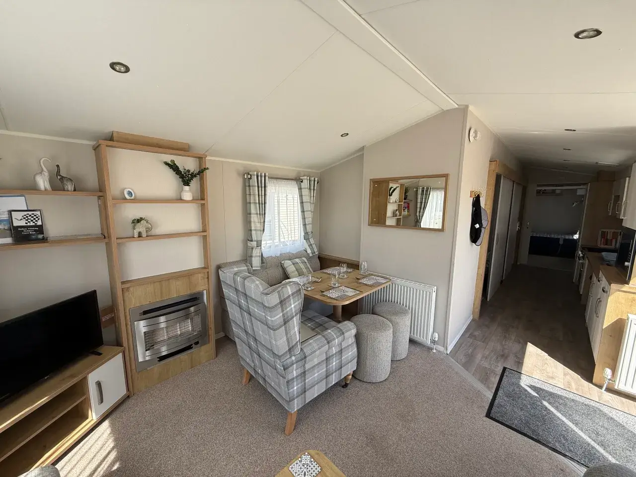 Lounge dining nook with shelving, TV unit, and gas fire.