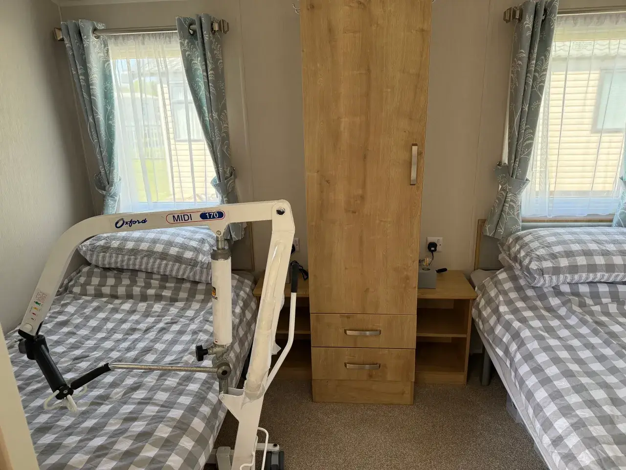 Twin beds with mobile hoist and wardrobe between.