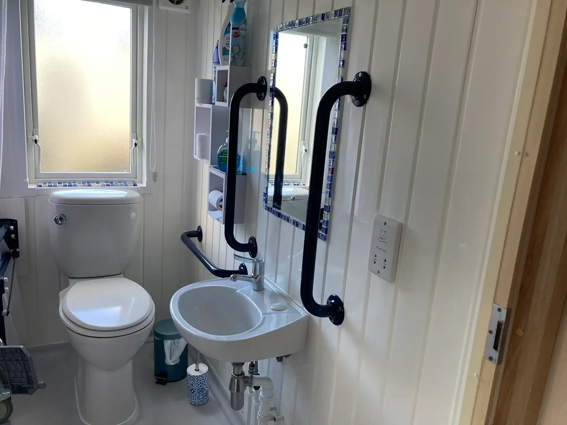 Accessible bathroom with sink, toilet, and black grab rails.