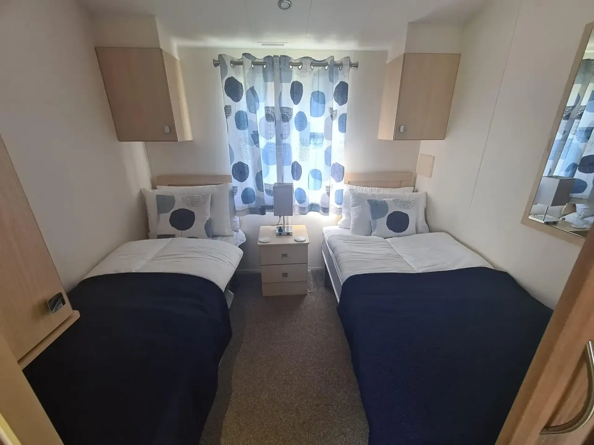 Twin bedroom with two single beds and bedside cabinet.