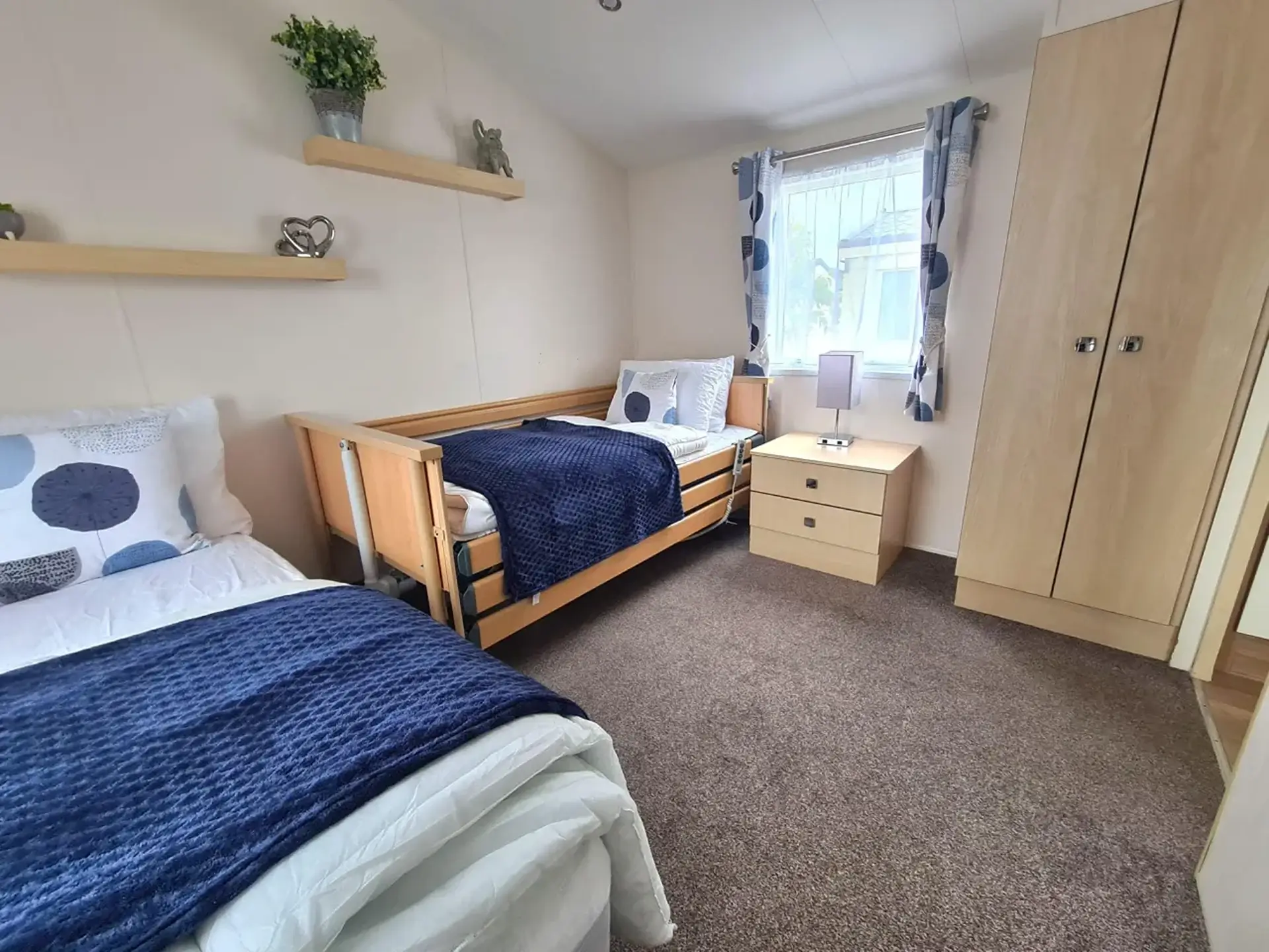 Bedroom with adjustable hospital-style bed beside a standard bed.