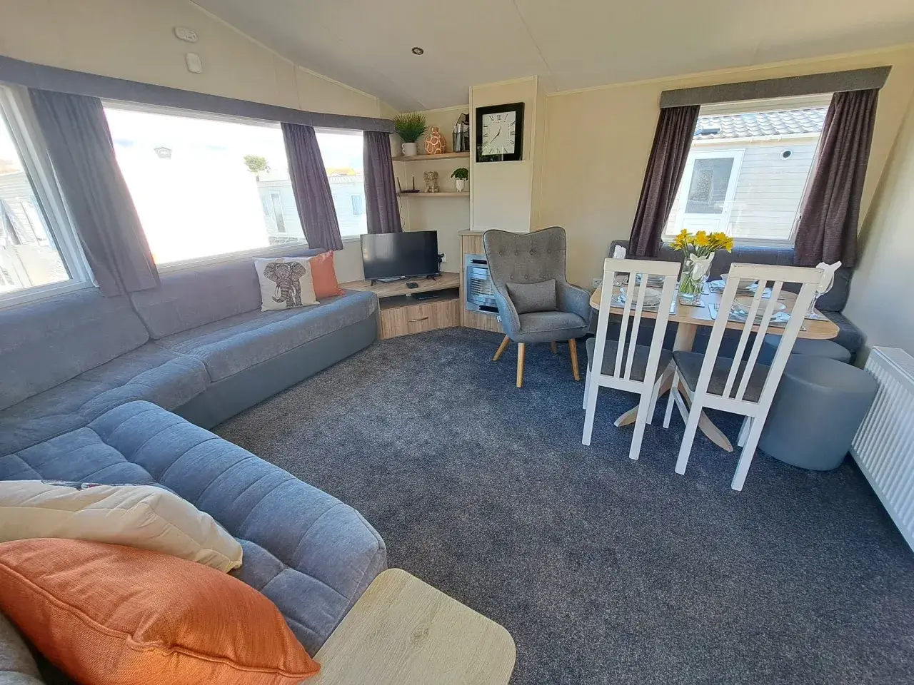 Blue corner sofa, dining table, and armchair in open-plan lounge.