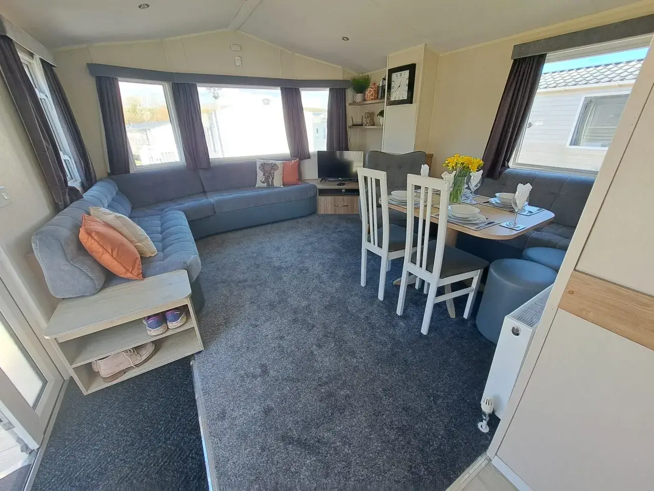 Lounge and dining area with corner sofa and shoe storage unit.