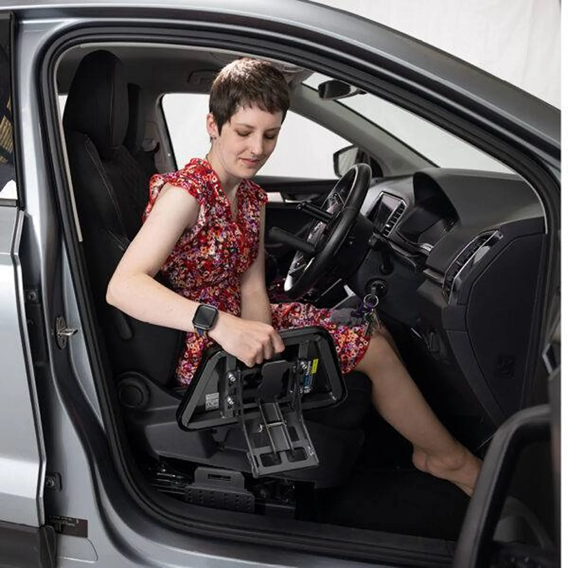 Woman in driver seat rotating the transfer plate mechanism with her hand.