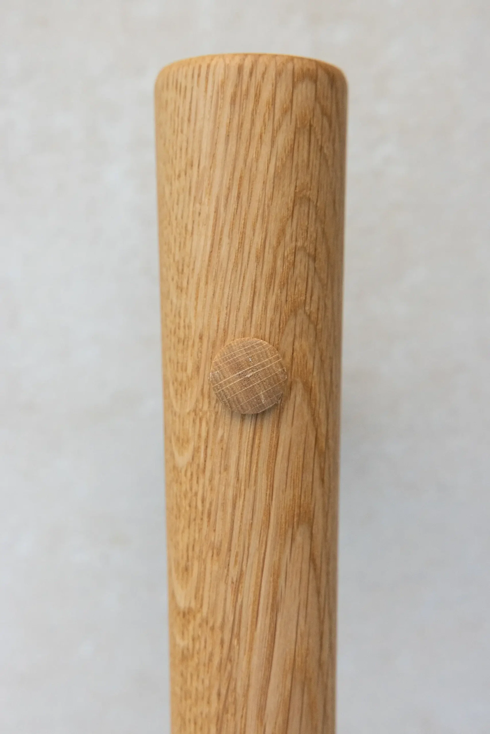 Close-up of a wooden dowel peg detail on an oak rail.