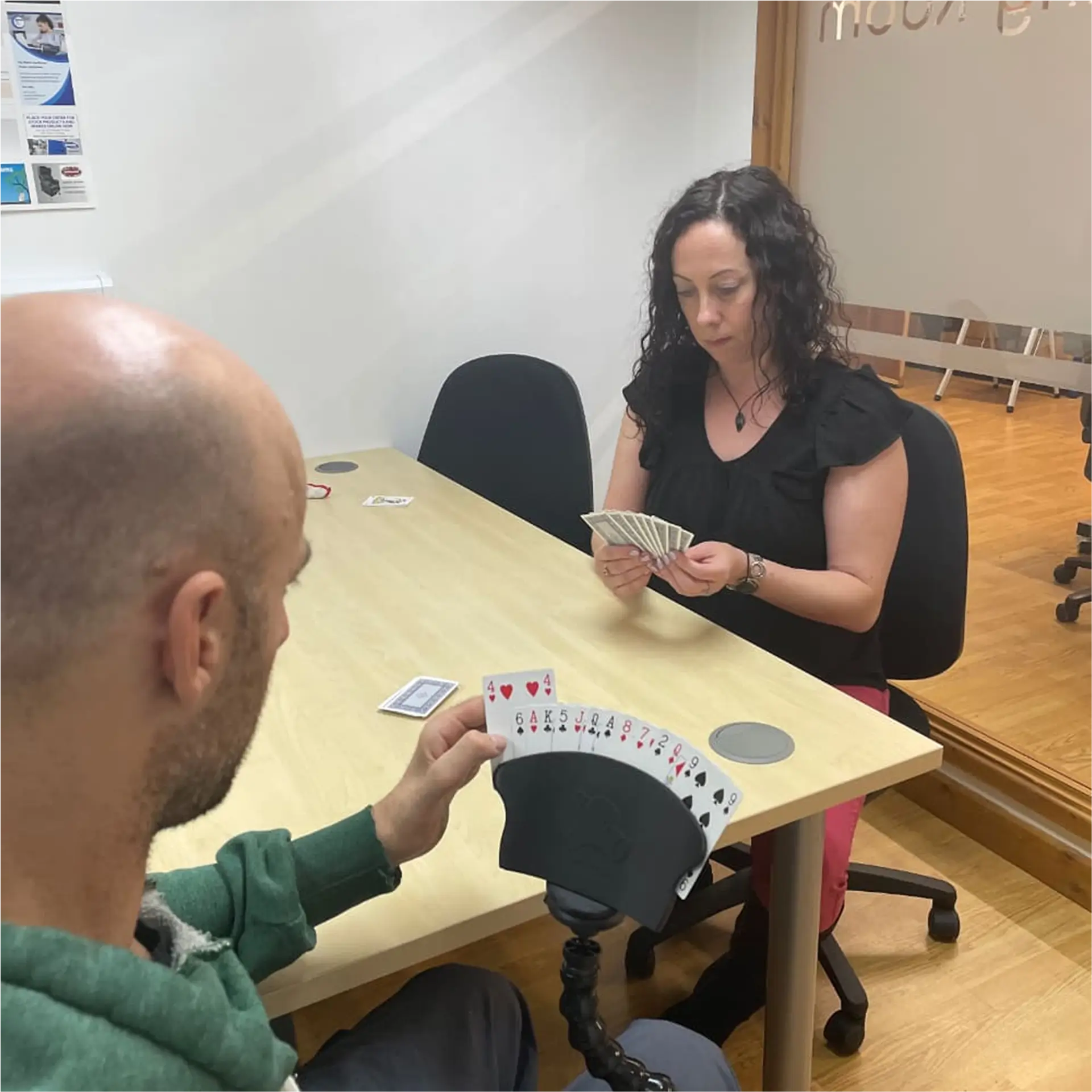 Man in wheelchair playing cards using card holder mount.