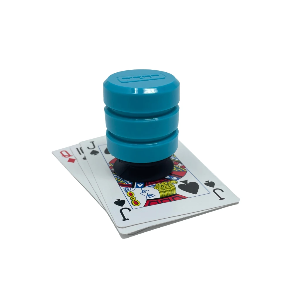 Teal grip tool sitting on top of stacked playing cards.