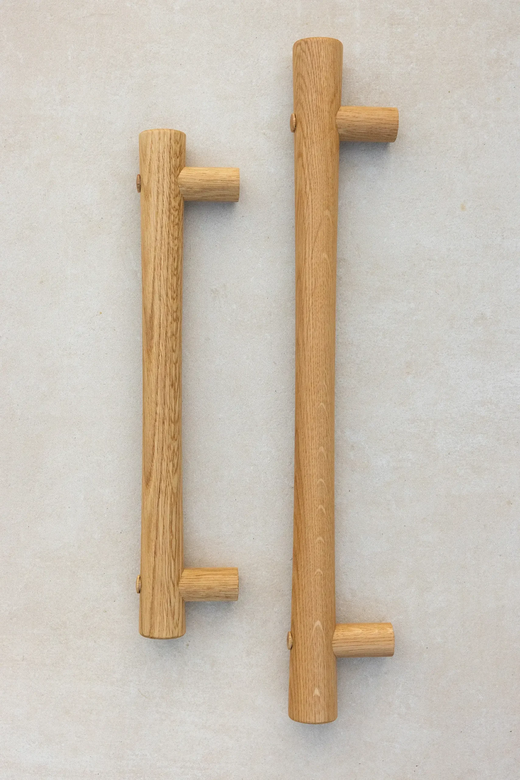 Two oak grab rails of different lengths laid flat.