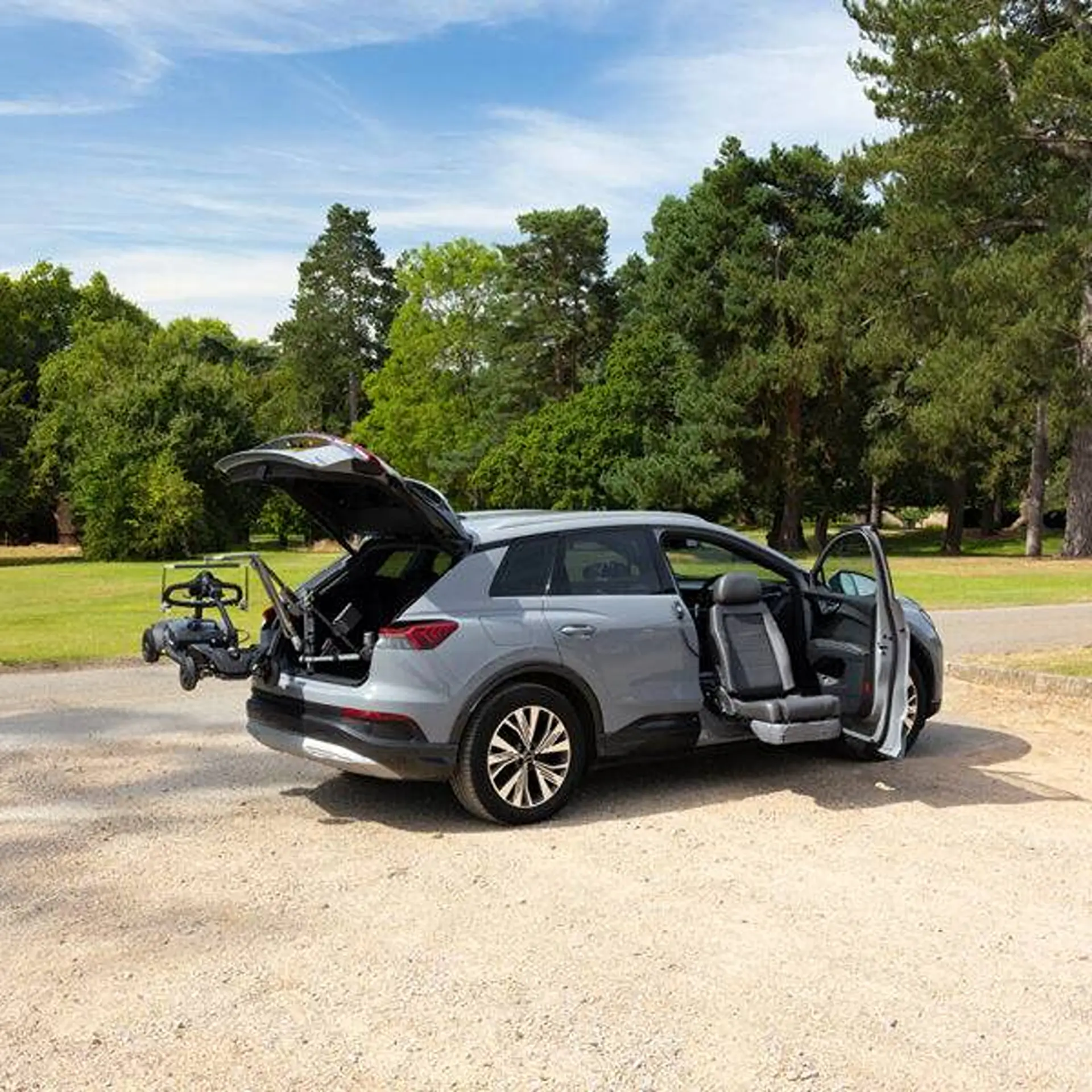 Audi SUV with tailgate and door open, scooter held by the extended lifter arm.