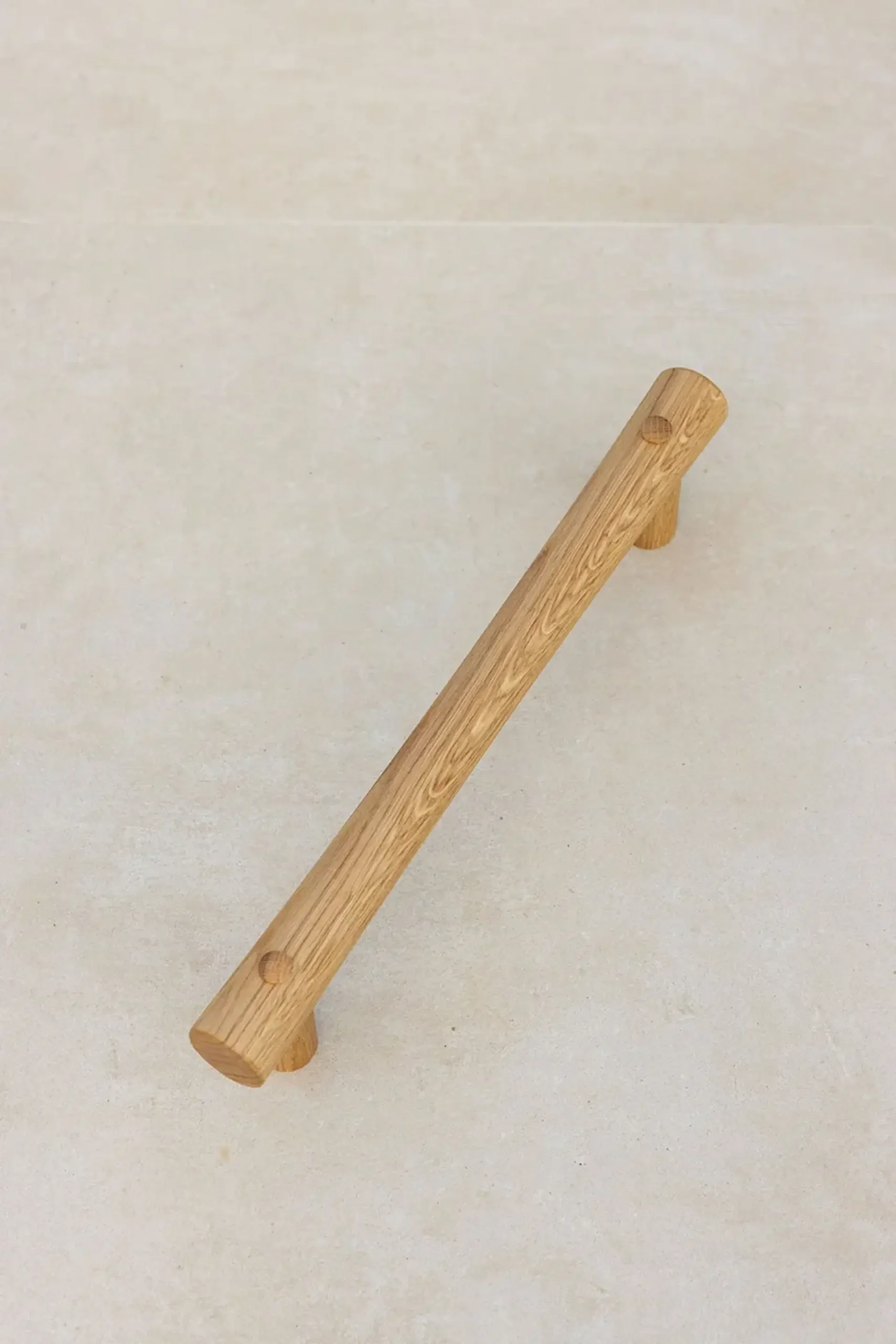 Oak grab rail on a stone surface, showing wood grain.
