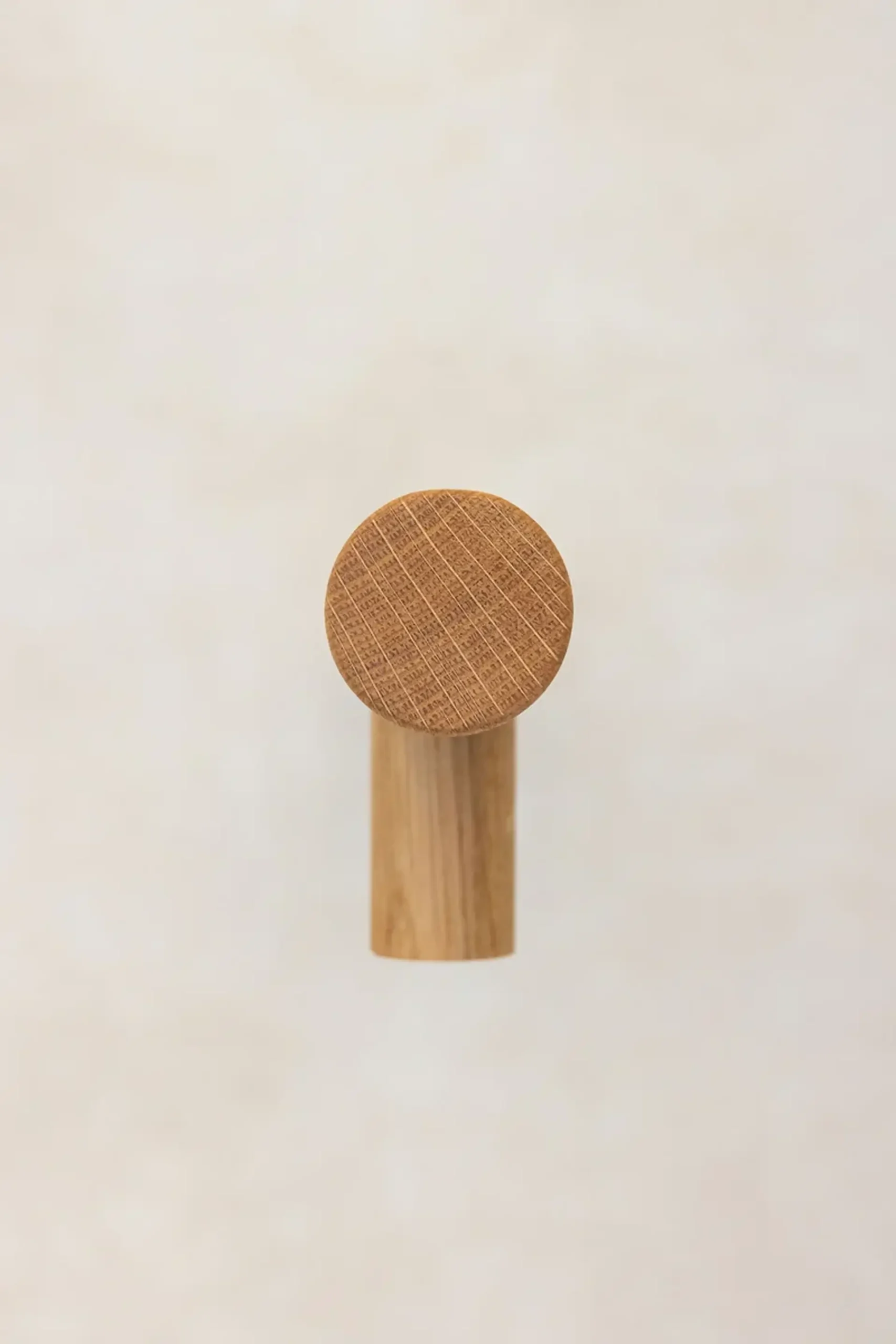 Full-length oak grab rail mounted vertically on a concrete wall.