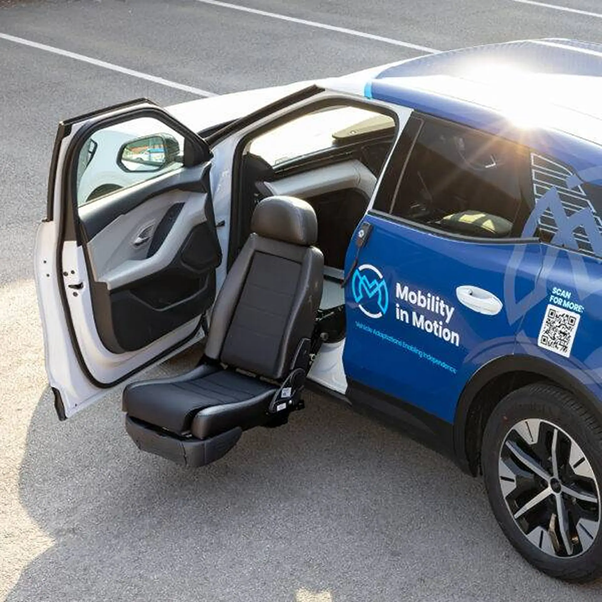 Overhead view of a car's seat swivelled and extended through the open door.