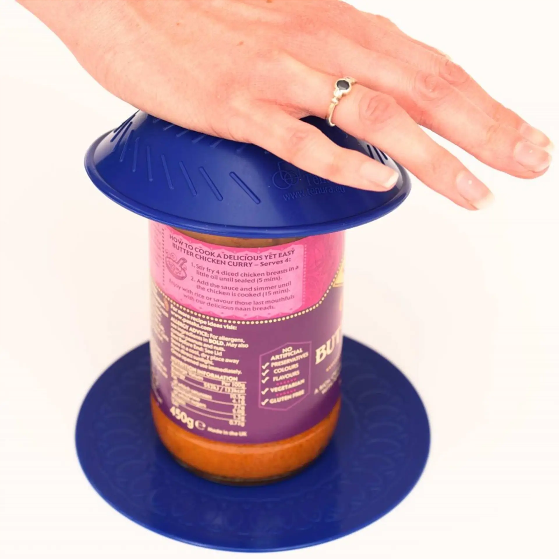 Hand pressing jar opener lid onto curry jar.