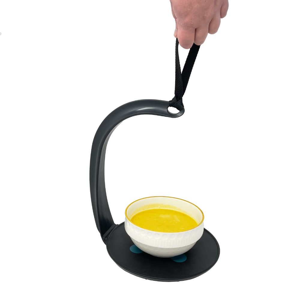 Hand carrying bowl of soup using strap-handled bowl holder.